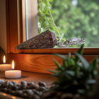 Rhodochrosite pendulum on a windowsill with tealight candles