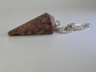 Rhodochrosite stone pendulum on a silver chain against a light grey background