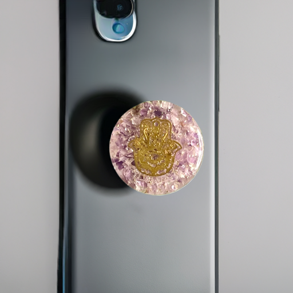 Amethyst circle phone grip with a gold hamsa hand on the back of a grey phone
