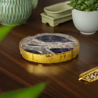 Amethyst crystal charging plate with gold edge on a dark wooden table