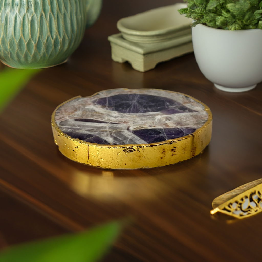 Amethyst crystal charging plate with gold edge on a dark wooden table